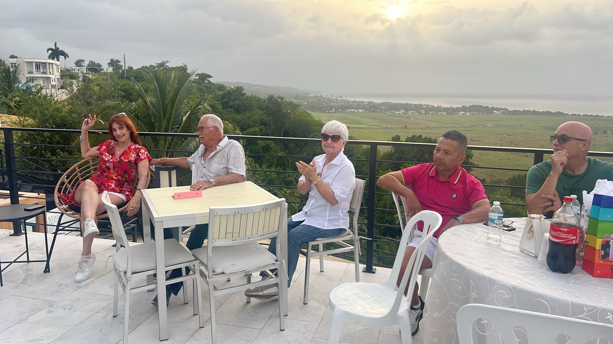 Guests enjoying an outdoor gathering around a patio dining table with scenic views at Blue Malibu PR