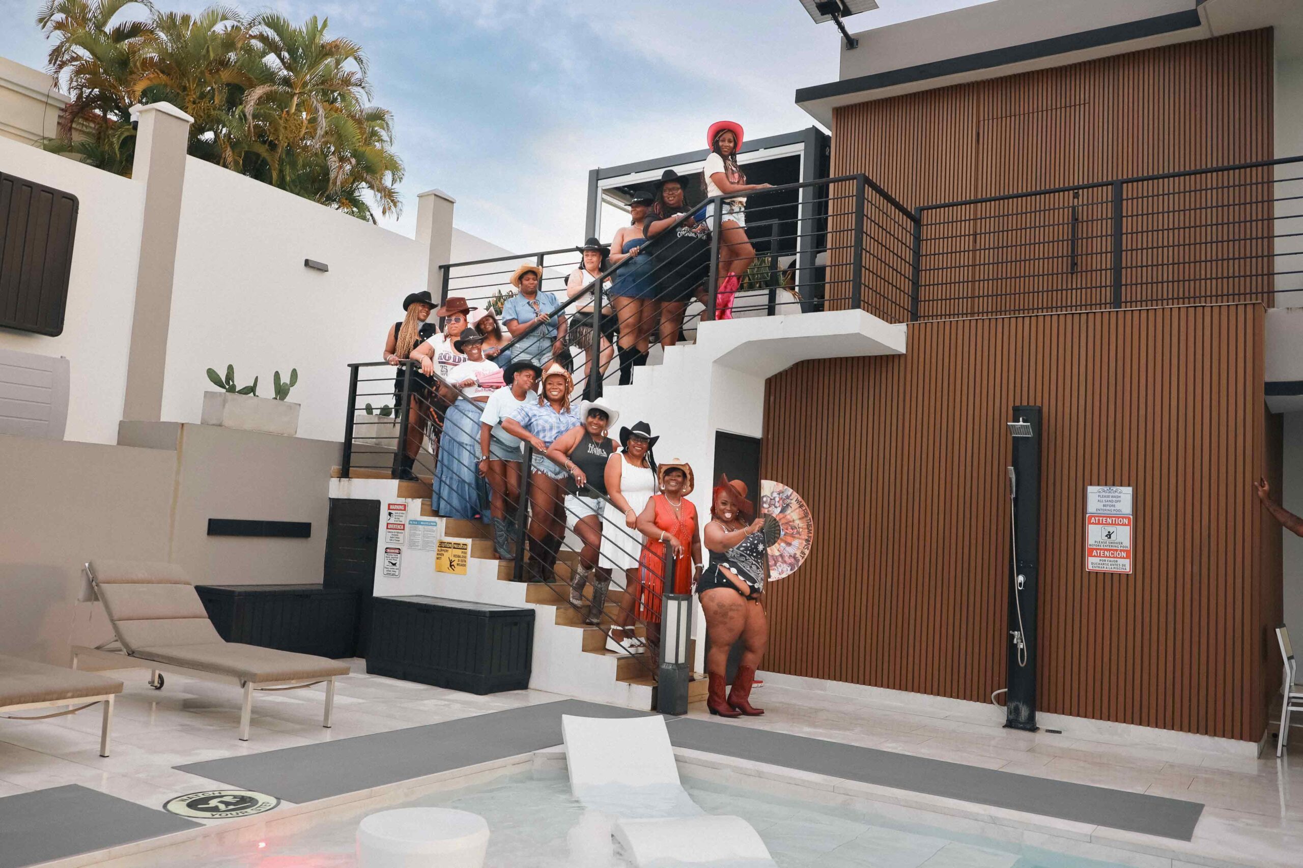 Group of guests celebrating on the outdoor staircase and balcony at Blue Malibu PR event venue in Camuy