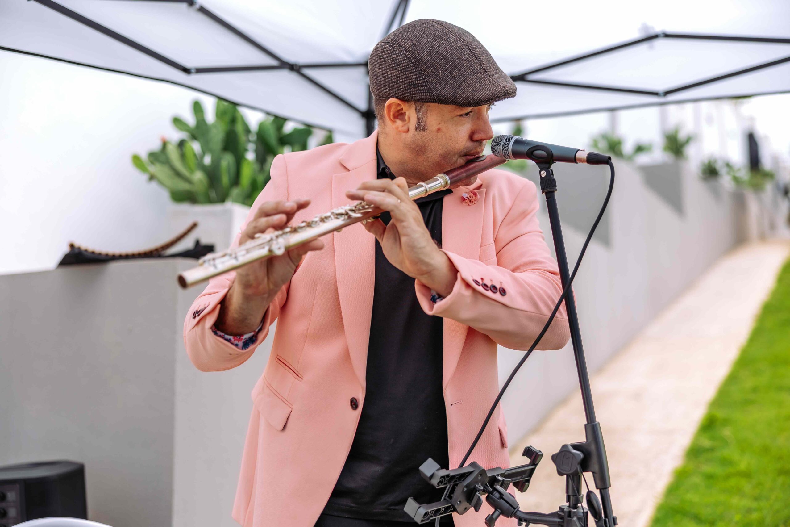 Live flute musician performing under an outdoor canopy during a Blue Malibu PR private event