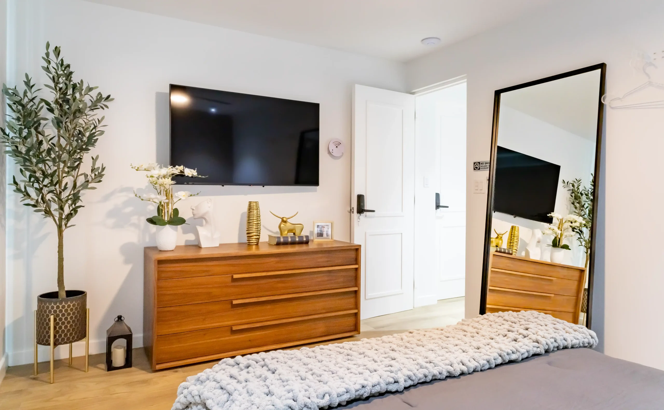 Modern furnished bedroom with wooden dresser and television at Blue Malibu PR