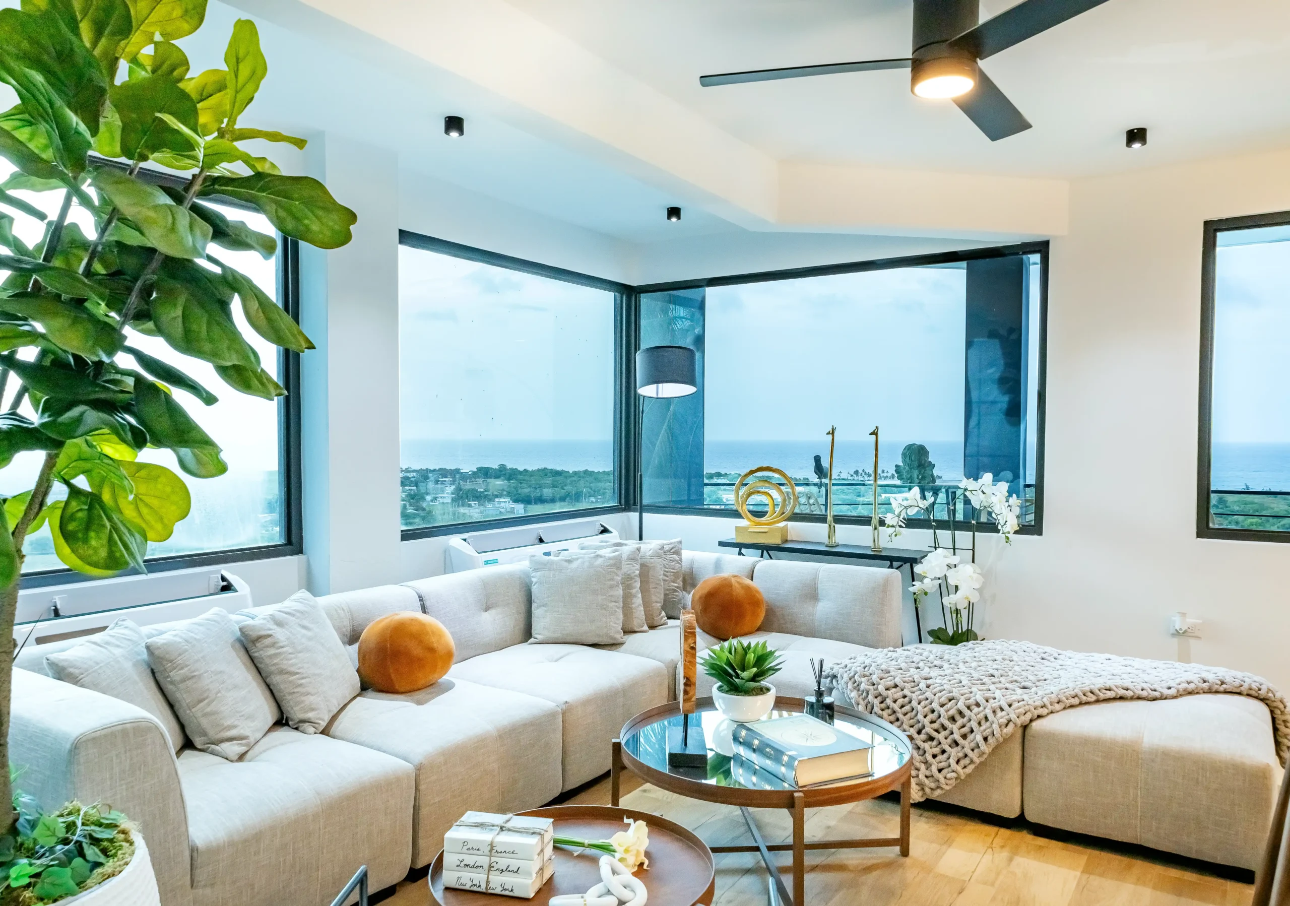 Bright living room with comfortable sofas, coffee table and panoramic windows overlooking the coast at Blue Malibu PR