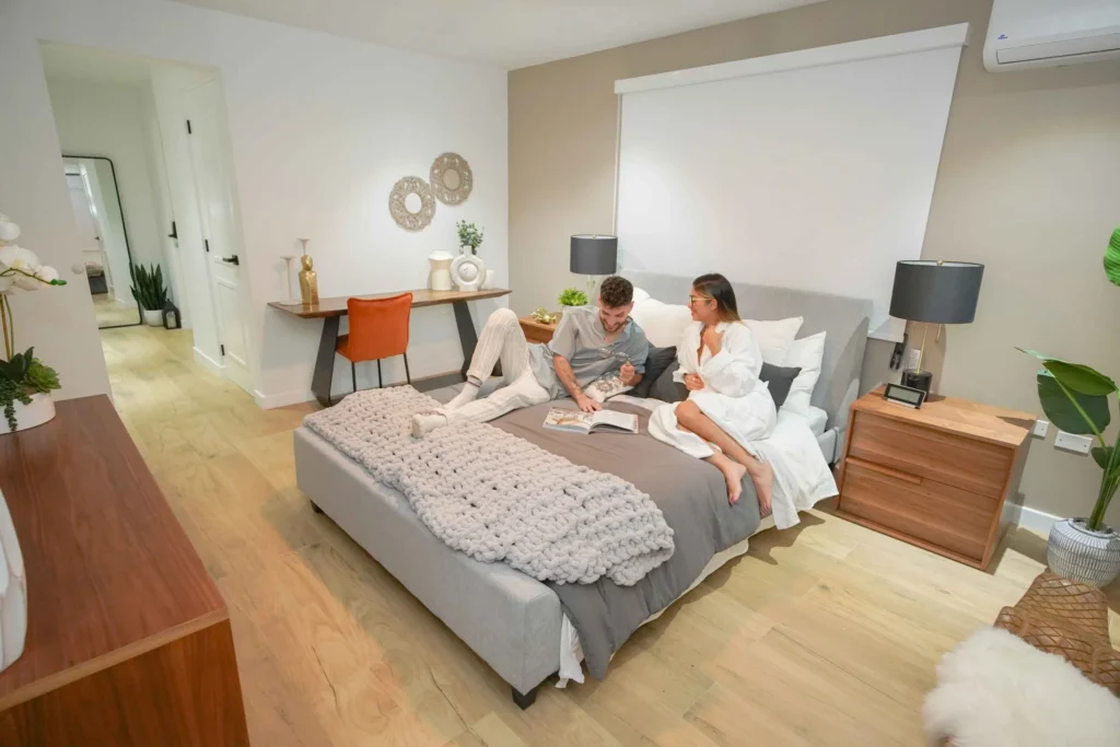 Guests relaxing on a bed in a modern bedroom at Blue Malibu PR villa rental in Camuy Puerto Rico